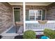 Charming front porch with brick facade, decorative welcome sign, and seating for relaxing at 9752 Brook Wood Dr, McCordsville, IN 46055