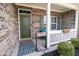 Inviting front porch featuring a brick exterior, 'Welcome' sign, and blue seating for relaxing at 9752 Brook Wood Dr, McCordsville, IN 46055
