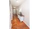 Well-lit hallway with hardwood floors, console table, and view of the front entrance at 9752 Brook Wood Dr, McCordsville, IN 46055