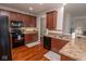 Modern kitchen boasts stainless steel appliances, hardwood floors, and adjacent dining and living spaces at 9752 Brook Wood Dr, McCordsville, IN 46055