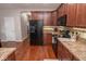 Modern kitchen offers sleek black appliances, warm wood cabinets, and plenty of room for cooking and storage at 9752 Brook Wood Dr, McCordsville, IN 46055