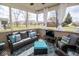 Relaxing outdoor patio featuring comfortable seating, a TV, and screened enclosure with views of the backyard at 9752 Brook Wood Dr, McCordsville, IN 46055