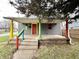 Charming front porch with colorful posts on a home with gray siding and a red front door at 980 Edgemont Ave, Indianapolis, IN 46208