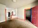 Cozy living room showing carpet, colorful door trim, and glimpses of the kitchen in the background at 980 Edgemont Ave, Indianapolis, IN 46208
