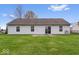 A serene backyard featuring a well-maintained lawn and patio with sliding glass door at 9856 Commonwealth Dr, Fishers, IN 46038