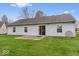 A serene backyard featuring a well-maintained lawn and patio with sliding glass door at 9856 Commonwealth Dr, Fishers, IN 46038