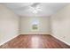 Spacious bedroom featuring a ceiling fan, window with natural light, and beautiful hardwood flooring at 9856 Commonwealth Dr, Fishers, IN 46038