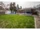 Well-maintained backyard featuring green lawn, above-ground pool, deck with pergola, and brick home at 1019 N Lesley Ave, Indianapolis, IN 46219