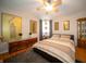 Bedroom featuring hardwood floors, ceiling fan, accent wall, and neutral decor at 1019 N Lesley Ave, Indianapolis, IN 46219