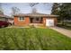 Charming brick home features a well-manicured lawn and attached garage, with inviting curb appeal at 1019 N Lesley Ave, Indianapolis, IN 46219