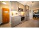 Another angle of the kitchen showing stove, stainless steel appliances, gray cabinets, and eat-in dining space at 1019 N Lesley Ave, Indianapolis, IN 46219