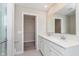 Bathroom with dual sinks, white cabinetry, and a walk-in closet for ample storage at 1239 Newton St, Avon, IN 46123
