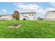 Large backyard with vibrant green grass and a fire pit, perfect for outdoor gatherings at 14060 Princewood Dr, Fishers, IN 46037