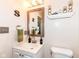 Cozy half bath featuring vanity with white cabinetry, a framed mirror, and decorative wall accents at 14060 Princewood Dr, Fishers, IN 46037
