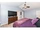 Spacious bedroom with vaulted ceiling and a dresser with television and doorways to closets at 14060 Princewood Dr, Fishers, IN 46037