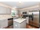 Well-lit kitchen featuring stainless steel appliances, gray cabinets, and an island for meal preparation at 14060 Princewood Dr, Fishers, IN 46037