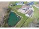Aerial shot of home featuring a private pond, patio area, and lush green lawn at 1471 S Frog Pond Ct, Greenfield, IN 46140