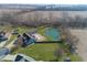 Drone shot of home with large pond, pool, in-ground trampoline, and three car garage at 1471 S Frog Pond Ct, Greenfield, IN 46140