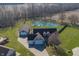 Stunning aerial view of home with large pond, dock, in-ground pool, and three-car garage at 1471 S Frog Pond Ct, Greenfield, IN 46140