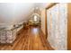 Hallway view of attic space showing ample area for a craft or workspace, featuring wood floors at 1471 S Frog Pond Ct, Greenfield, IN 46140