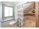 Bright bathroom with tiled shower, shower curtain, and window seat at 1471 S Frog Pond Ct, Greenfield, IN 46140