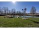 Picturesque pond featuring two docks, a windmill, and lush greenery at 1471 S Frog Pond Ct, Greenfield, IN 46140