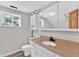 Bathroom with a vanity, decorative mirror, sink, and a window for natural light at 1707 Rocky Ford Rd, Columbus, IN 47203