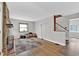 Spacious living room with hardwood floors, stone fireplace, and staircase access to the second floor at 1707 Rocky Ford Rd, Columbus, IN 47203