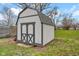 Charming shed with gray and white trim and barn-style doors in the backyard at 1707 Rocky Ford Rd, Columbus, IN 47203