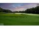 Beautiful green golf course surrounded by green trees and a colorful sky at sunset at 20598 Chatham Creek Dr, Westfield, IN 46074