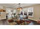 Elegant dining room with a modern chandelier, glass table, and views of the adjoining kitchen and living area at 2180 Olympia Dr, Franklin, IN 46131