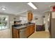 Well-lit kitchen with stainless steel appliances, wood cabinets, and easy access to the backyard at 2180 Olympia Dr, Franklin, IN 46131