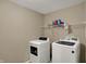 Well-lit laundry area featuring white appliances and overhead shelving for storage convenience at 2180 Olympia Dr, Franklin, IN 46131