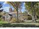 View of the home's back exterior featuring a stone and siding facade and a small raised deck and patio at 2872 Jeremy Ct, Carmel, IN 46033