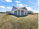 Backyard of a gray home with a covered patio, lush lawn and ample space for outdoor entertaining at 3124 Sharon Cir, Brownsburg, IN 46112