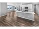 Open-concept kitchen with a large island, white cabinets, stainless appliances, and wood flooring at 3124 Sharon Cir, Brownsburg, IN 46112
