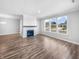 Spacious living room with hardwood floors, a cozy fireplace, and bright windows for natural light at 3124 Sharon Cir, Brownsburg, IN 46112
