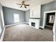 Cozy living room with neutral carpet, gray walls, a white brick fireplace, and a ceiling fan at 316 W 6Th St, Anderson, IN 46016