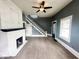 Inviting living room with fireplace, neutral carpet, gray walls, staircase, and ceiling fan at 316 W 6Th St, Anderson, IN 46016