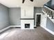 Inviting living room with fireplace, neutral carpet, gray walls, and staircase to the second floor at 316 W 6Th St, Anderson, IN 46016