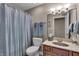 Cozy bathroom featuring a shower with blue curtain, wood vanity, and soft lighting at 350 N Meridian St # 610, Indianapolis, IN 46204