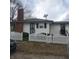 Home's rear exterior featuring brick chimney and white picket fence at 3701 N Audubon Rd, Indianapolis, IN 46218