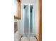 Bathroom featuring a shower with blue tiling and an adjacent window for natural light at 4108 Carson Ave, Indianapolis, IN 46227