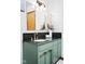Stylish bathroom featuring a green vanity with a black countertop and modern fixtures at 4108 Carson Ave, Indianapolis, IN 46227