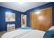 A bedroom with deep blue walls, a closet, and a neatly made bed at 4108 Carson Ave, Indianapolis, IN 46227