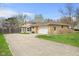 Wide exterior shot of home showing stone detail, a large driveway, and backyard at 4108 Carson Ave, Indianapolis, IN 46227