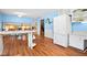 View of kitchen with white refrigerator, countertops, and barstool seating with a view into adjacent dining area at 4108 Carson Ave, Indianapolis, IN 46227