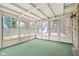 Bright sunroom with multiple windows offering views of the fenced backyard and storage shed at 4108 Carson Ave, Indianapolis, IN 46227