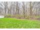 Lush backyard merging with a dense forest area beyond a white fence, blending nature with residential comfort at 4135 Benicia Ln, Indianapolis, IN 46235