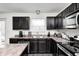 Corner kitchen view featuring stainless steel appliances and dark cabinets at 4135 Benicia Ln, Indianapolis, IN 46235